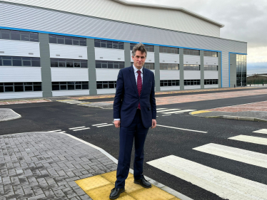 Sir Gavin Williamson standing outside the controversial distribution warehouse developments near Stone